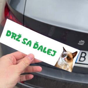 Nálepka "DRŽ SA ĎALEJ" s mačkou na aute.