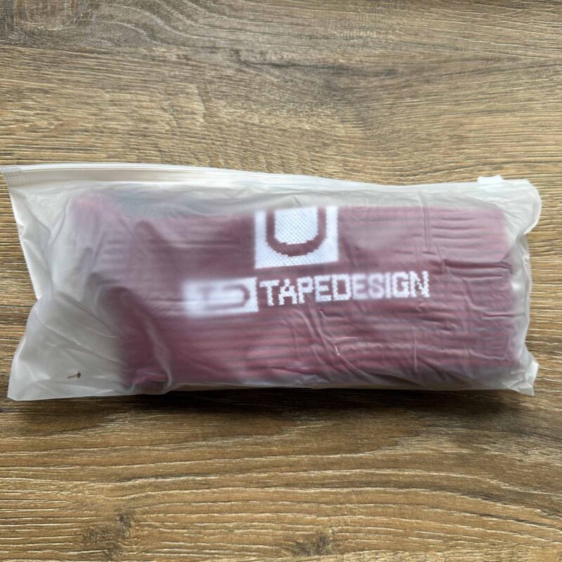 Zabalený športový produkt, TapeDesign, na drevenom povrchu.