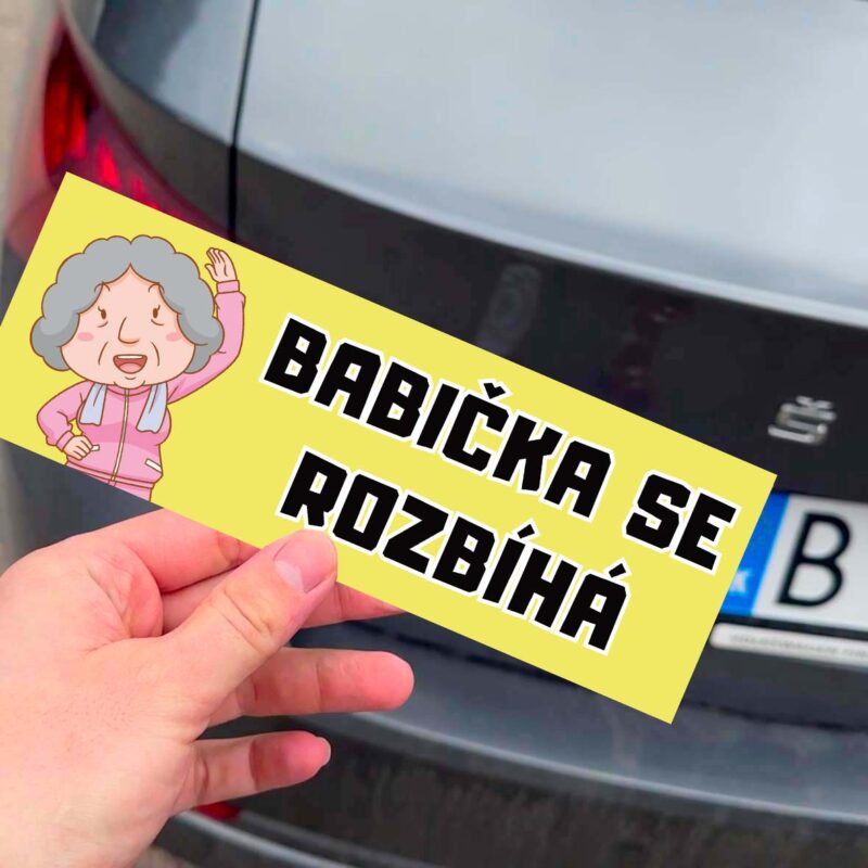 Nálepka s nápisom "Babička se rozjíždí" a karikatúrou.