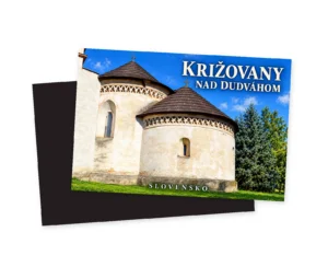 Náhľad magnetky Križovany nad Dudváhom s románskou rotundou, dvomi šindľovými strechami a trávnikom; za potlačenou stranou je tmavá zadná strana.