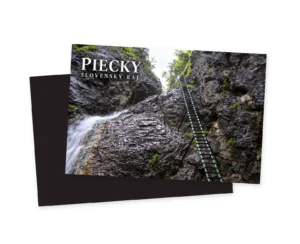 Fotografia zhora nadol do rokliny Piecky ukazujúca tmavú skalnú stenu, vodný prúd vľavo a dlhý úzký železný rebrík vedúci k presvetlenému otvoru.
