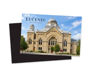 Fotorealistická grafika lučeneckej synagógy s centrálnou sivou kupolou, biela vežička vľavo, vrstvený oblúk na štíte a krémovo-okrová tehlová fasáda pri slnečnom svetle.